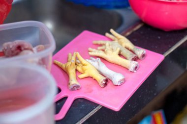 Pişirmek için doğrama tahtasının üzerinde çiğ tavuk ayağı