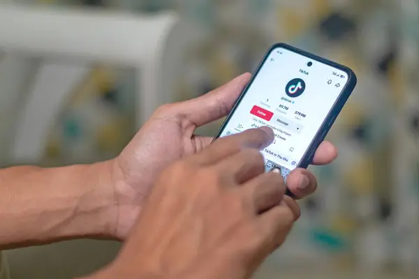 Jakarta, Endonezya - 11 Mayıs 2025: Akıllı telefonda TikTok uygulaması kullanan adam