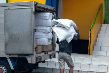 Jakarta, Endonezya - 05 Mayıs 2025: Geleneksel bir pazar yerinde pirinç veya un çuvalları taşıyan bir işçi veya hamal 