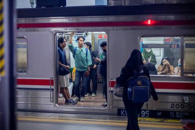 Jakarta, Endonezya - 07 Haziran 2025: banliyö treni istasyonda duruyor. Yolcular trene binsin. Kapı açık.