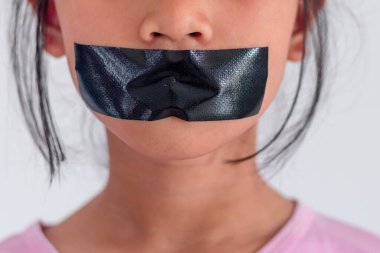 Ağzında siyah bantla genç bir kız.