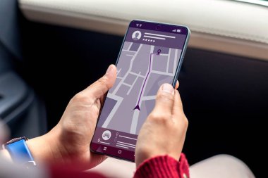İnternetten taksi rezervasyonu. Arabadaki bir kadın akıllı telefonunda cep telefonu uygulaması kullanarak internetten taksi sipariş ediyor.. 
