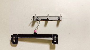 Soyunma odasındaki duvarda asılı boş bir elbise askısı.