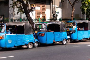 Jakarta, Endonezya - 10 Ağustos 2025: Yol kenarına park edilmiş sıkıştırılmış doğal gazdan güç alan üç tekerlekli toplu taşıma.