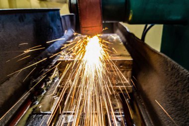Makinede öğütülen metal, kıvılcımlar hazneye doğru uçar. Ön görünüm