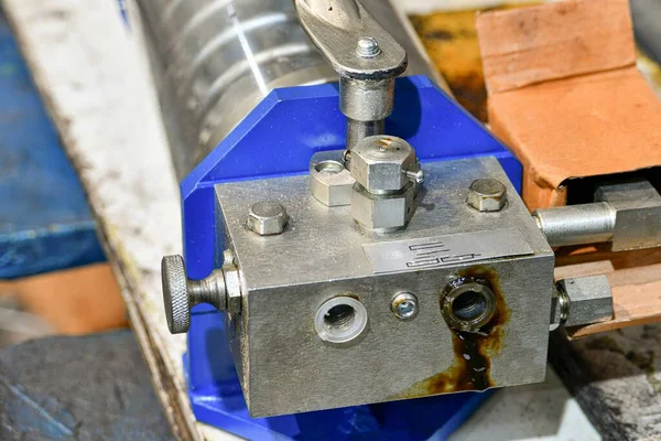 Hydraulic hand pump being repaired in a workshop.