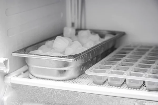 Frozen ice cubes in a stainless steel bowl in the freezer