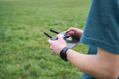 Çocuk uzaktan kumandayı kullanarak kuadkopterin uçuşunu kontrol ediyor..