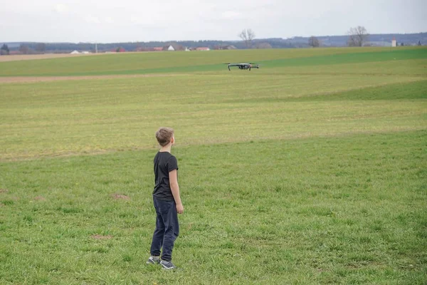 Boy Controls Flight Quadcopter Using Remote Control — Stock Photo, Image