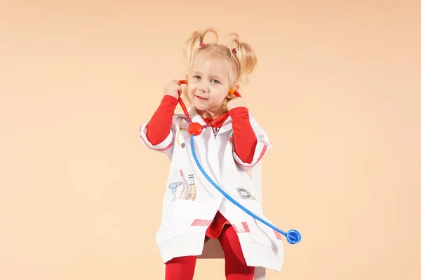 A little girl with a stethoscope plays doctor.
