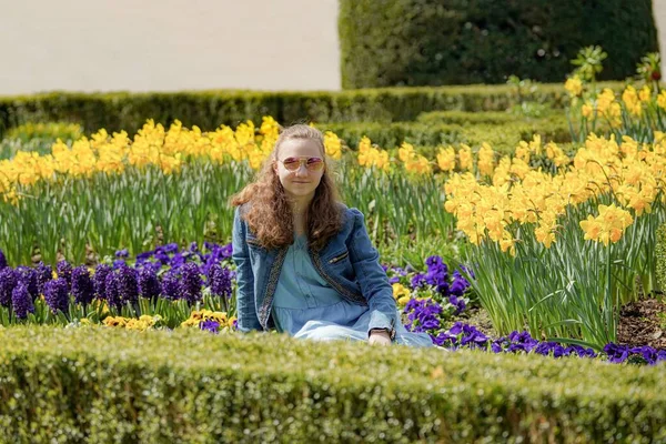 Egy Napszemüveges Lány Pózol Virágok Között Egy Tavaszi Napon — Stock Fotó