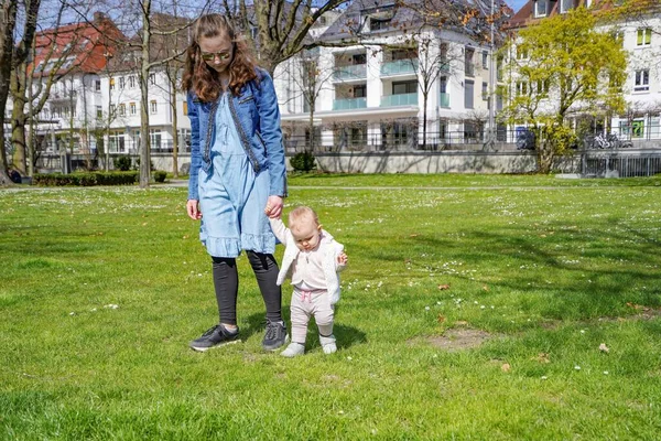 Egy Fiatal Anya Egy Gyerekkel Füvön Sétál Megtanít Egy Kisgyereket — Stock Fotó