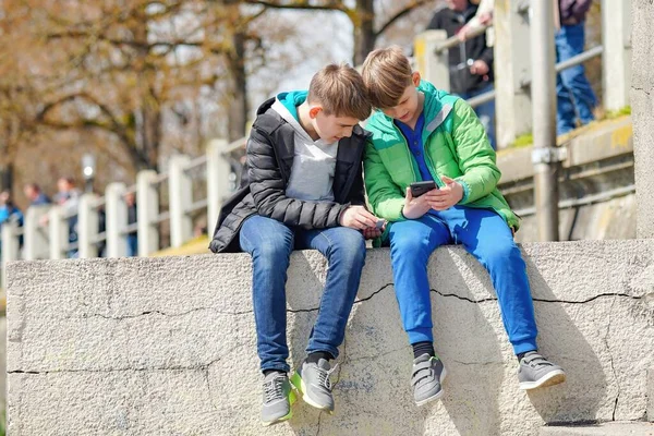 Deux Adolescents Jouent Avec Des Téléphones Dans Parc Photo Haute Photo De Stock