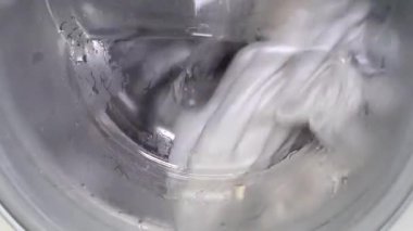 Çamaşır makinesinde kirli çarşafları yıkamak. Otomatik yıkama ve durulama kipleri.