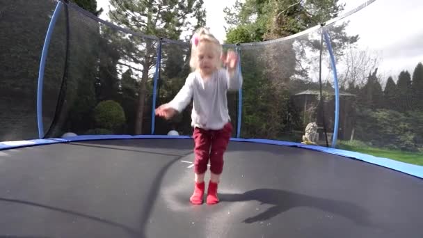 Ένα Μικρό Κορίτσι Πηδά Ένα Τραμπολίνο Και Κάνει Διάφορα Ακροβατικά — Αρχείο Βίντεο