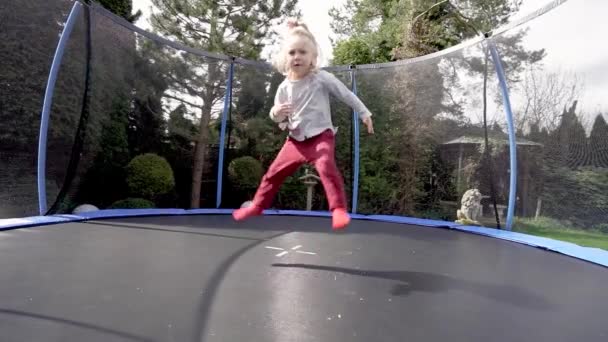 Een Klein Meisje Springt Een Trampoline Doet Verschillende Acrobatische Stunts — Stockvideo