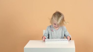 Küçük bir kız bir klavye alıyor, yazı yazıyor ama hiçbir şey işe yaramıyor. Yüksek kalite 4k görüntü