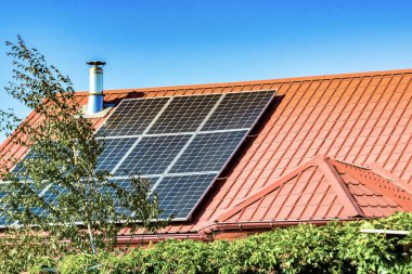 Bir kır evinin çatısında güneş panelleri, elektrik güneş enerjisi çevresel üretim.
