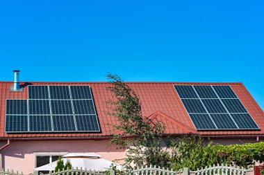 Bir kır evinin çatısında güneş panelleri, elektrik güneş enerjisi çevresel üretim.