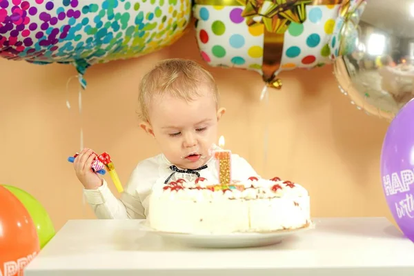 一个小孩在一个生日蛋糕旁边的气球背景上过生日 高质量的照片 — 图库照片