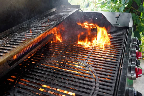 ガスグリルの火は 肉を調理するためにグリルグレート上の脂肪を調理します — ストック写真