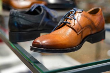 Mağaza vitrininde satılık kahverengi ayakkabılar..