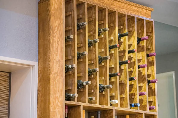 Bottles of collectible wine on a wooden rack.