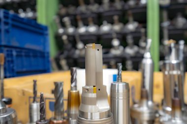 Mills bir kutu içinde CNC makinesi üzerinde çalışmak için bir raf karşı araçlar ile bir raf.