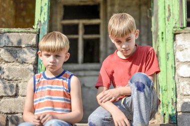 Children in a burnt house lost their homes as a result of hostilities and natural disasters. clipart