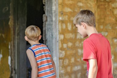Yanmış bir evde çocuklar, çatışmalar ve doğal afetler sonucu evlerini kaybettiler..