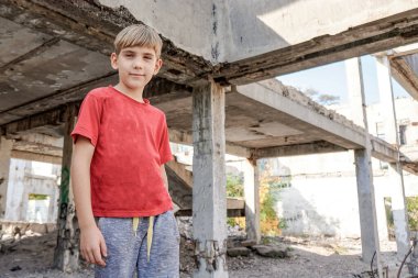 Terk edilmiş bir binada sığınacak yer arayan kirli ve aç bir çocuk..