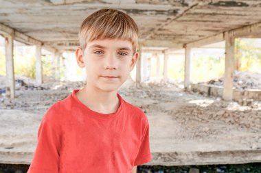 Terk edilmiş bir binada sığınacak yer arayan kirli ve aç bir çocuk..