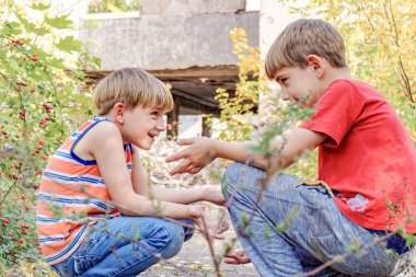 İki erkek çocuk parkta karşı karşıya oturur ve birbirleriyle iki kez iletişim kurarlar..