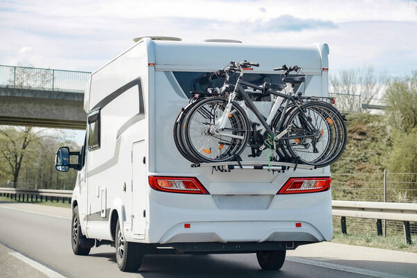 Мотодом на велосипедах движется по шоссе к кемпингу. Концепция туризма и отдыха.