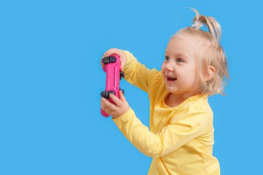 Oyun konsolundan elinde kumanda kolu olan küçük bir kız..