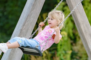 Küçük bir kız parkta salıncakta sallanıyor..
