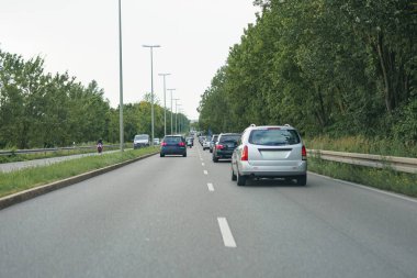 Hareket halindeki arabalarla dolu yüksek hızlı bir yol. Otoban ve arabalar.