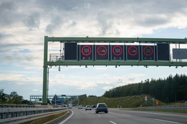 Yüksek hızlı bir otoyolda elektronik pano ve yol işaretleri.