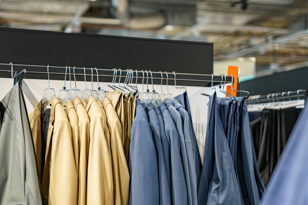 Hangers with men's suits for sale in a shopping mall.