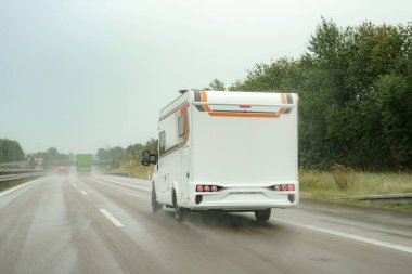 Otoyoldaki bir karavan yağmur altında yol boyunca ilerliyor..