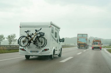 Otoyoldaki bir karavan, arabanın arkasında bisiklet taşır..