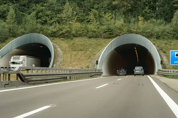 Bir otobanda bir araba bir tünelde yol boyunca gidiyor..