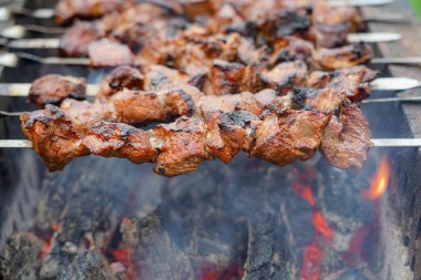 Shashlikler ızgarada kızarıyor. Şişte kızarmış et. Hafta sonu et barbeküsü.