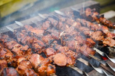 Shashlikler ızgarada kızarıyor. Şişte kızarmış et. Hafta sonu et barbeküsü.