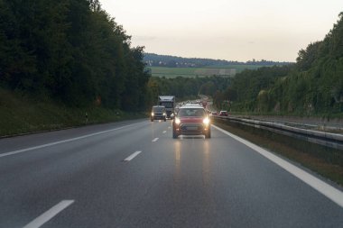 Düşük kirişli arabalar akşamları otoban boyunca sürüyorlar..