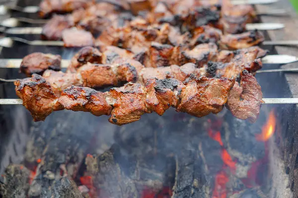 Shashlikler ızgarada kızarıyor. Şişte kızarmış et. Hafta sonu et barbeküsü.