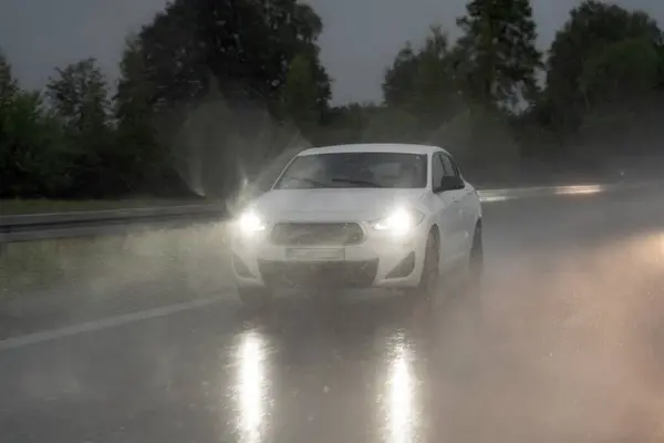 stock image Cars with low beams on drive along a motorway in the rain in the evening.