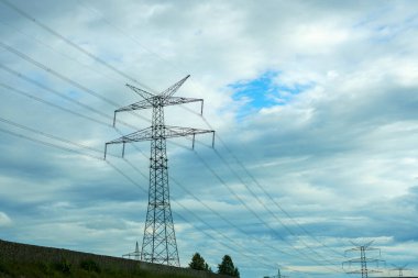 Akşam bulutlu gökyüzünün arka planında yüksek voltaj direği.