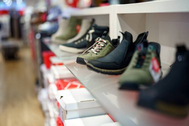 Alışveriş merkezinde sergilenen erkek spor ayakkabıları koleksiyonu.