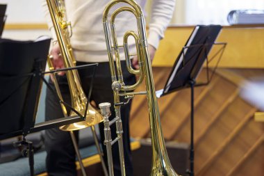 Bir trompet, bir pirinç müzik enstrümanı, bir orkestrada notaların yanında bir bankta yatıyor..